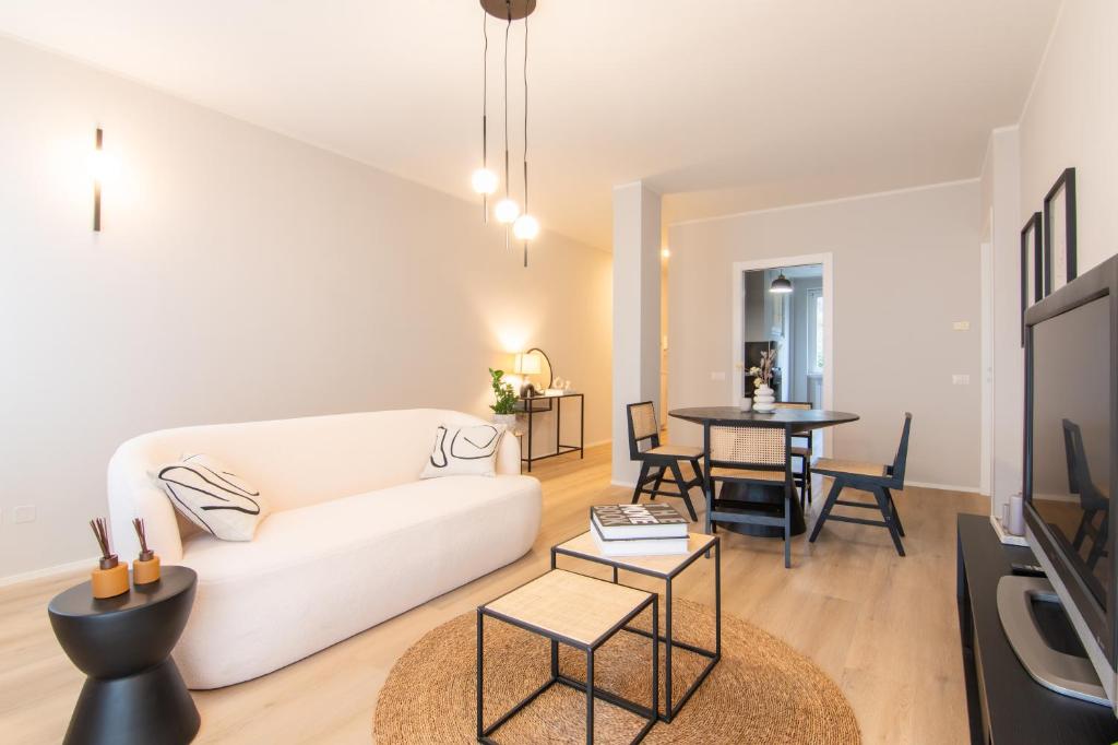 a living room with a white couch and a table at Appartamento Regina - Lake Como View in Gravedona
