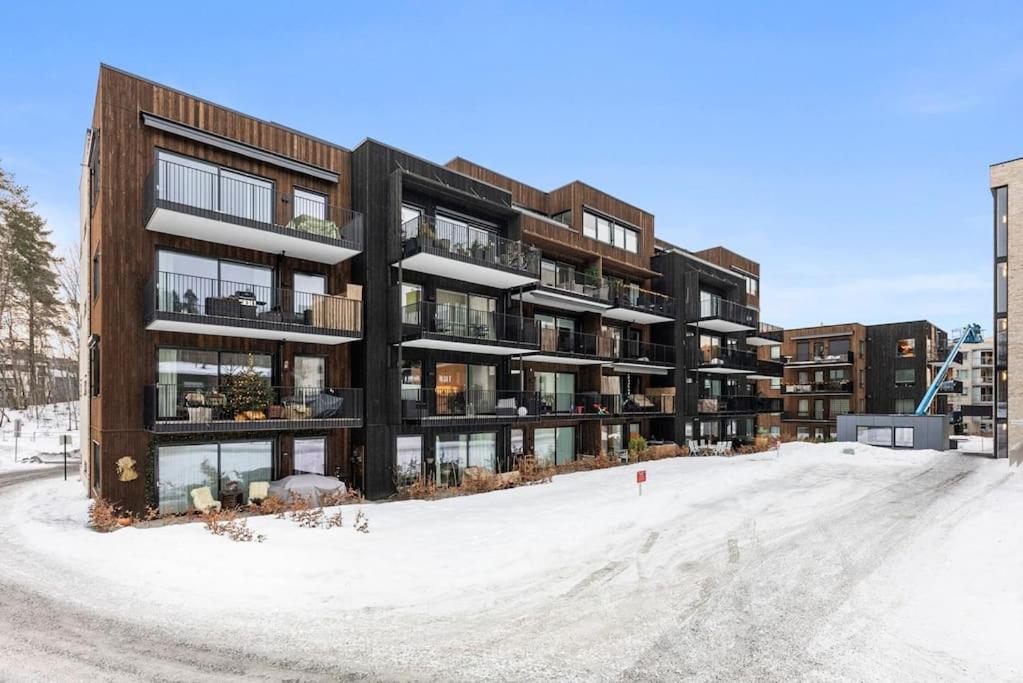 um edifício de apartamentos com neve no chão em Moderne Leilighet med 2soverom Sentral beliggenhet em Asker