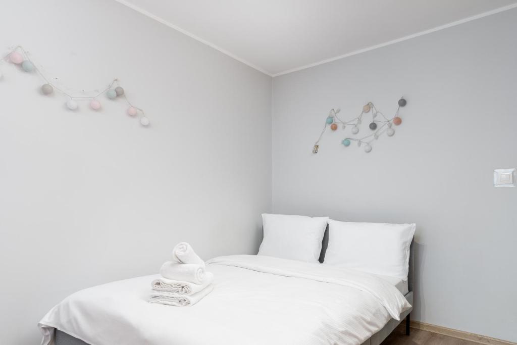 um quarto branco com uma cama com lençóis brancos em Krowoderskich Zuchów Standard Studio em Cracóvia