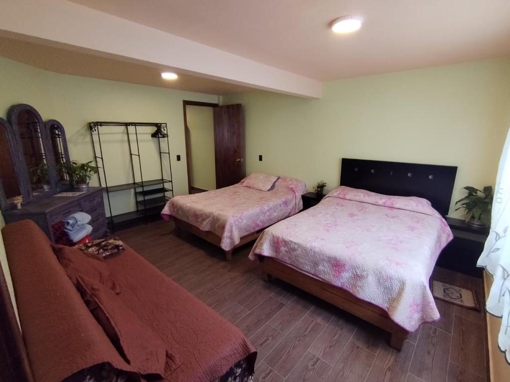 Habitación de hotel con 2 camas y espejo en Siempre Viva, en Chignahuapan