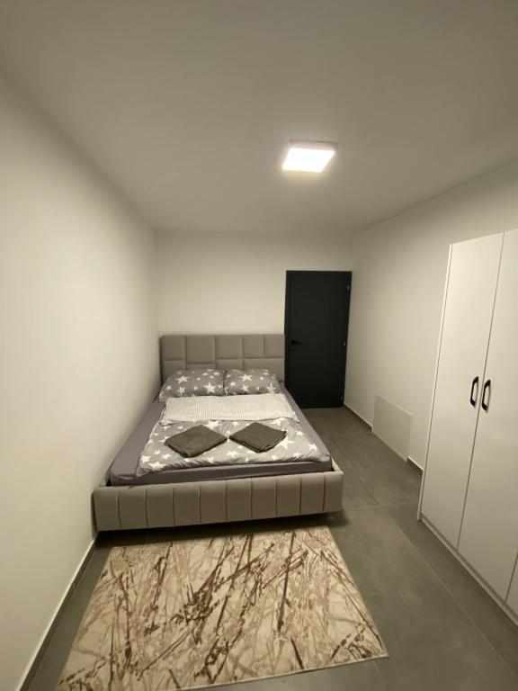 - une chambre avec un lit et un tapis au sol dans l'établissement Luxos Villa, à Ferizaj