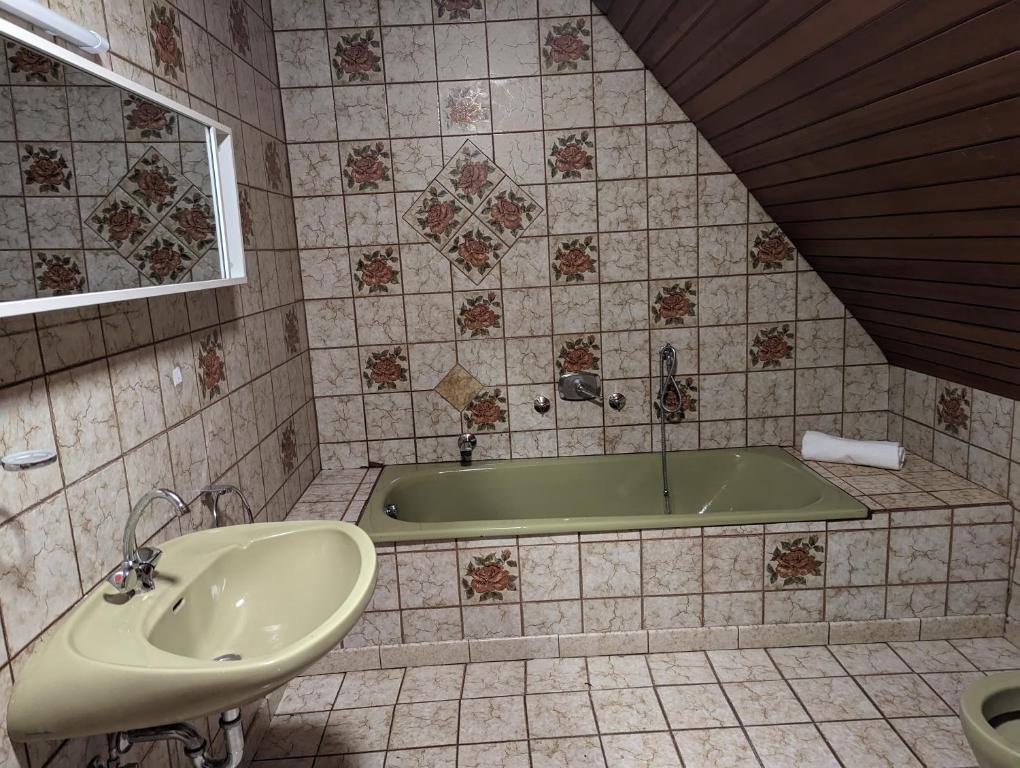 La salle de bains est pourvue d'une baignoire et d'un lavabo. dans l'établissement Ferienhaus mit Garten, à Rastatt