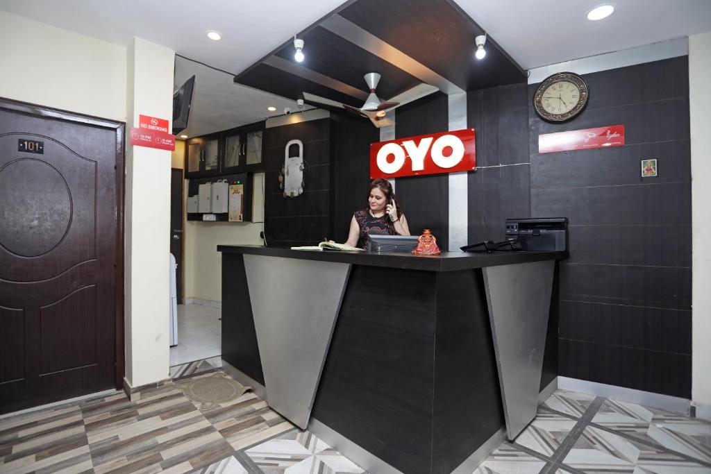 a woman sitting at a counter with a laptop at OYO Raj Palace in Meerut