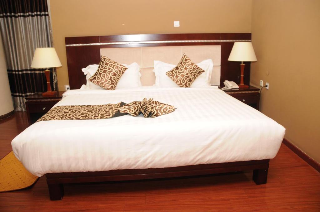 a bedroom with a large white bed with leopard pillows at Melka International Hotel in Addis Ababa