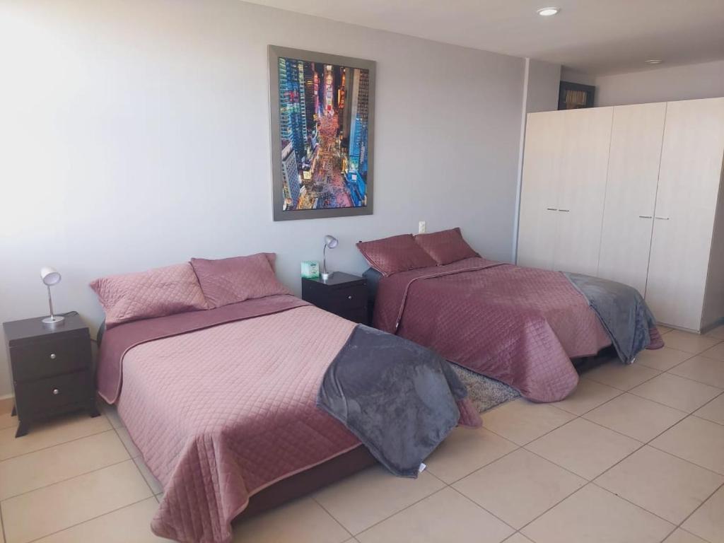 1 dormitorio con 2 camas y un cuadro en la pared en CARSO ALAMEDA BELLAS ARTES Loft Premium en Ciudad de México