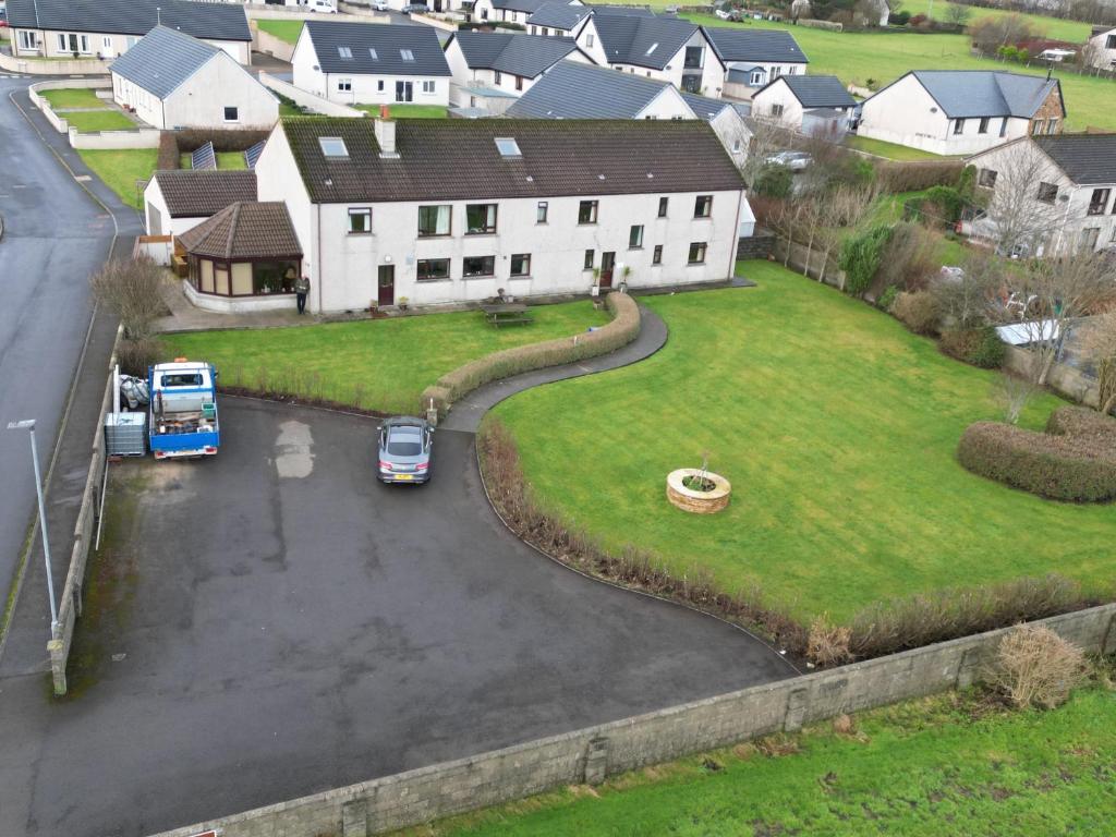 a house with cars parked in a parking lot at Polrudden in Orkney