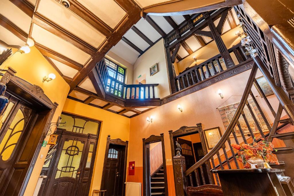 an indoor hallway with a staircase and a ceiling at Hotel Pod Zamkiem in Olsztyn