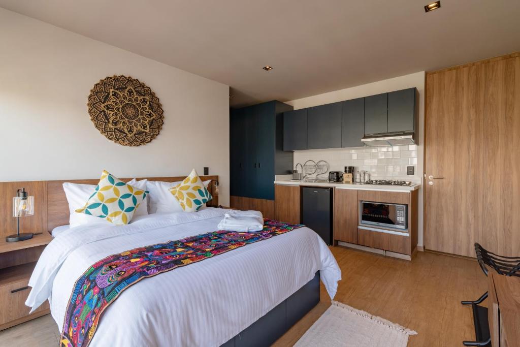 A studio room combining a large bed with a fully fitted kitchenette.