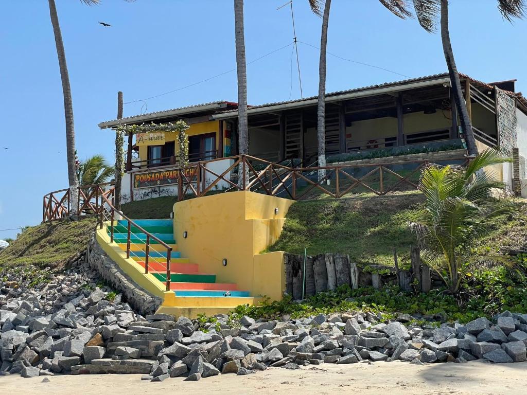 a house on top of a hill with rocks at Pousada Parracho in Maracajaú