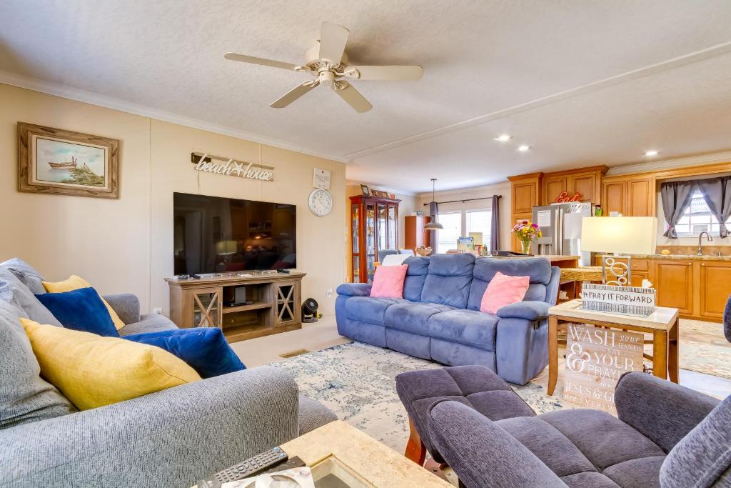 a living room with blue couches and a tv at Pensacola Family Vacation Rental Home with Grill! in Pensacola