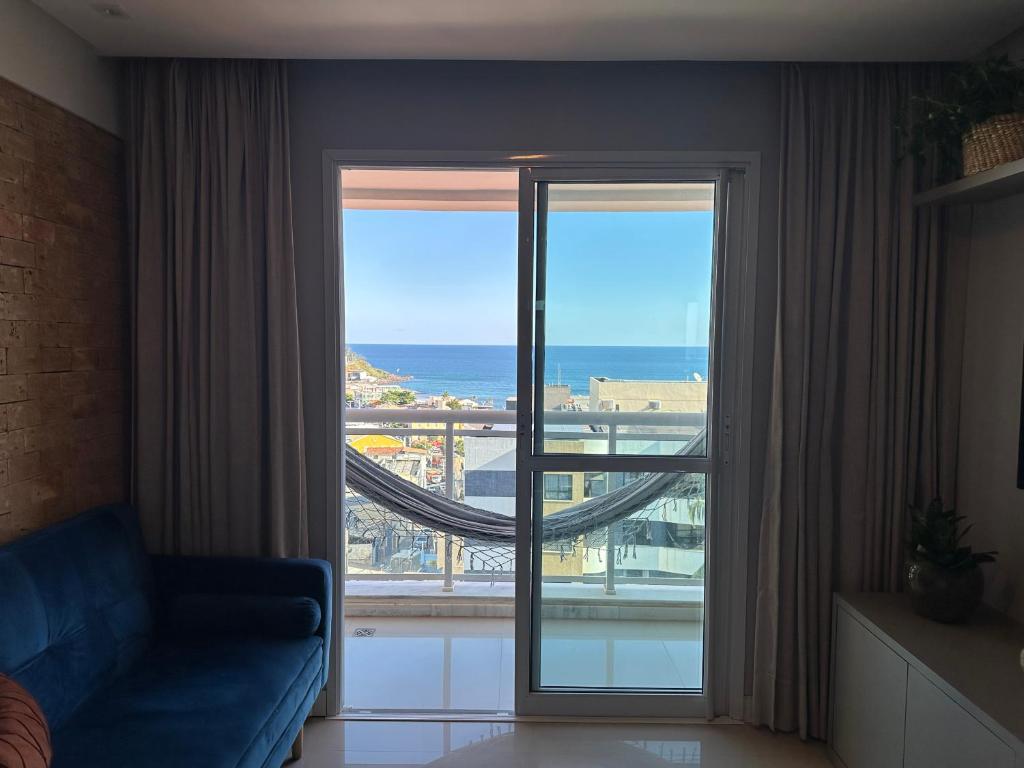 um quarto com uma grande janela com vista para o oceano em Apartamento Vista Mar aconchegante no Rio Vermelho em Salvador