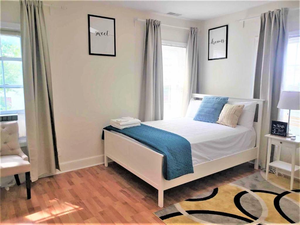 Grandeur Room in Washington DC في واشنطن: غرفة نوم بسرير أبيض مع بطانية زرقاء