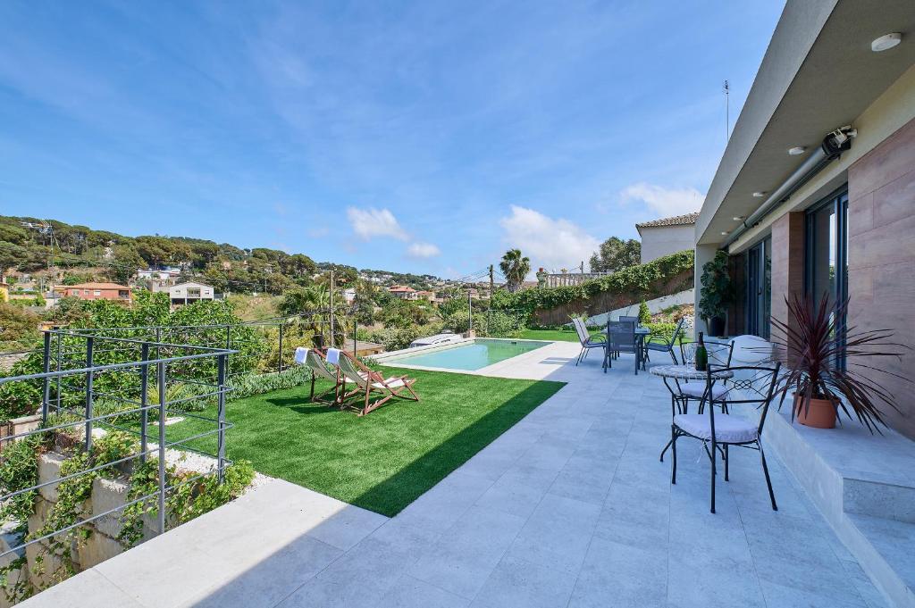 a patio with a lawn and a swimming pool at 2Agnes01 in Vidreres