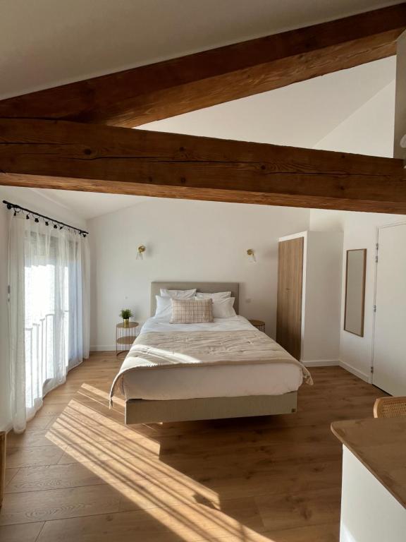 尼桑勒茲恩蘇涅的住宿－Le Chai，一间卧室设有一张大床和木制天花板