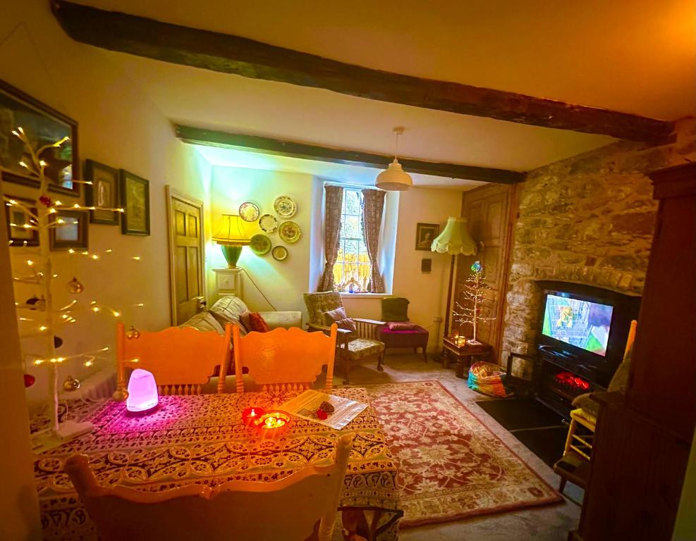 a living room with a table and a fireplace at Castle Buildings Cottage2 in Llanrhaeadr-ym-Mochnant