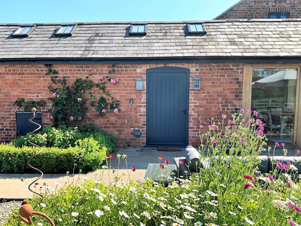 a brick house with a black door in a garden at 5 bed in Llangollen 77696 in Whitchurch