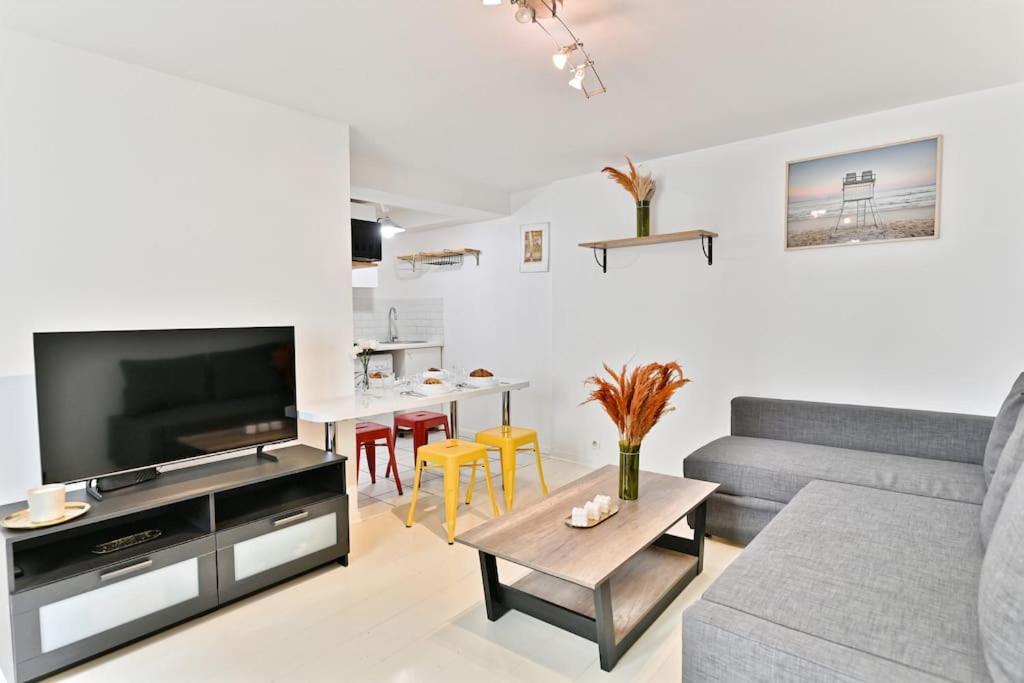 a living room with a couch and a table at Appartement proche Canal Saint Martin in Paris