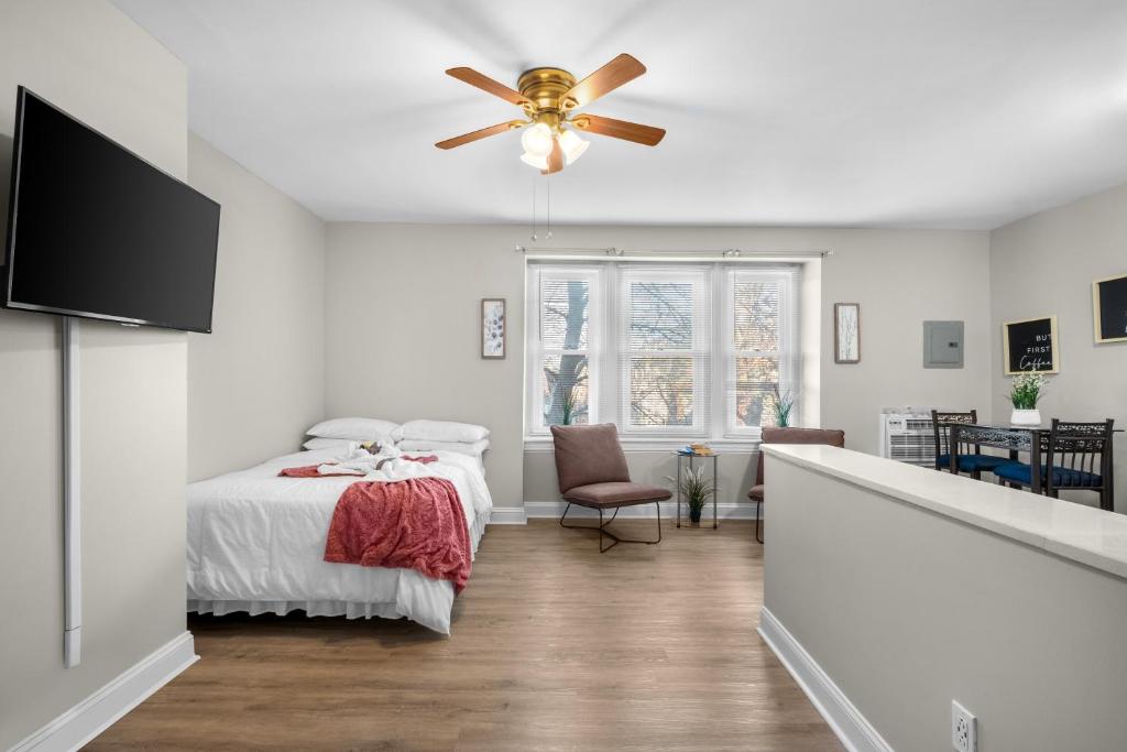 Schlafzimmer mit einem Bett und einem Deckenventilator in der Unterkunft A Cozy Perch With A City View in Philadelphia