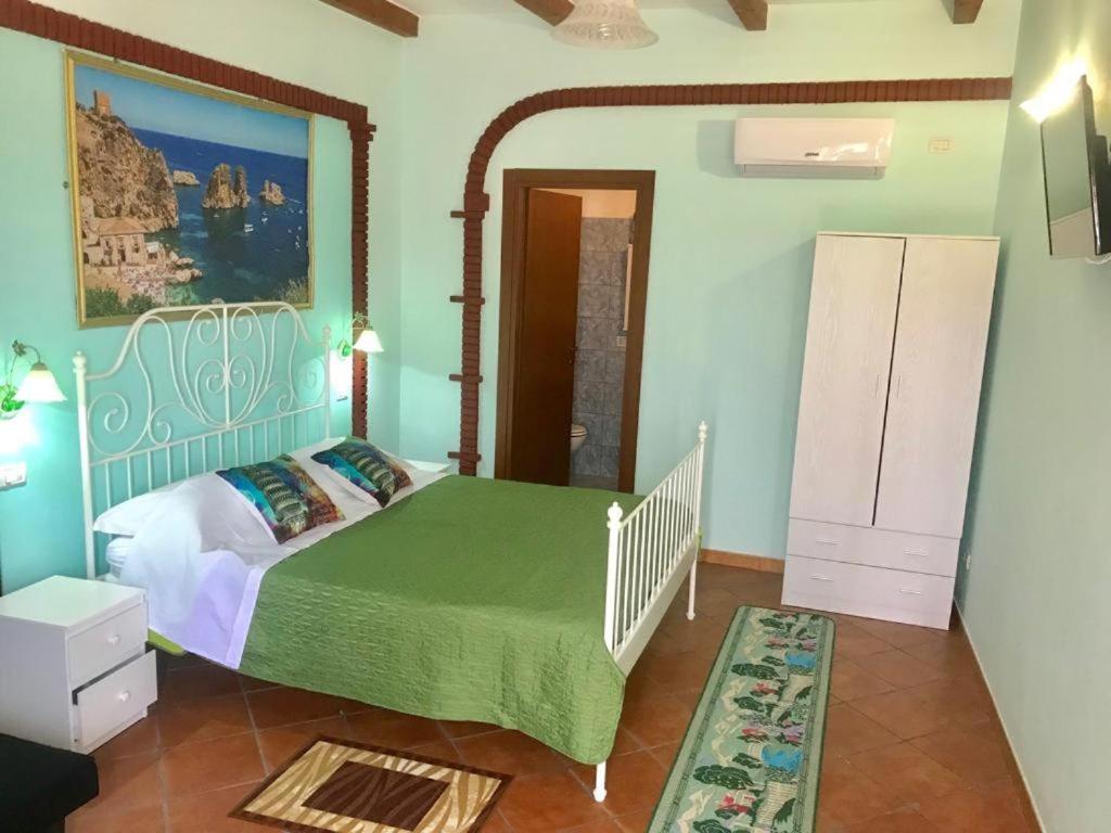sypialnia z łóżkiem z zieloną kołdrą w obiekcie B&B Teodora w mieście Gaggi
