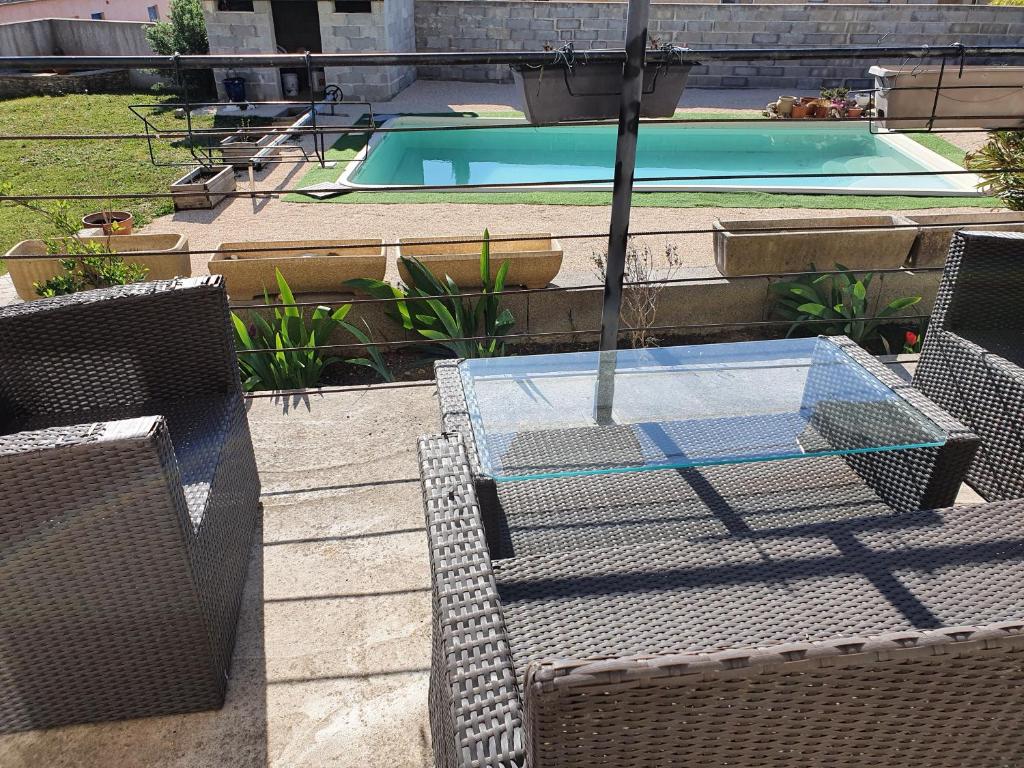 un patio avec une table et des chaises et une piscine dans l'établissement Les contemplations, à Barjac