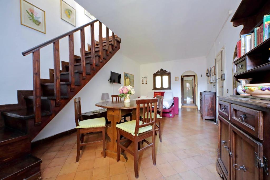 cocina y comedor con mesa y escaleras en St.Margherita Charming House, en Roma