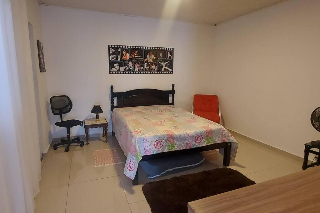 a small bedroom with a bed and a chair at casa da Déa in Mogi das Cruzes