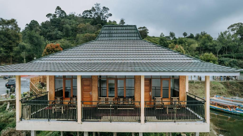 una casa con techo sobre el agua en Villa Situ Patenggang, en Ciwidey