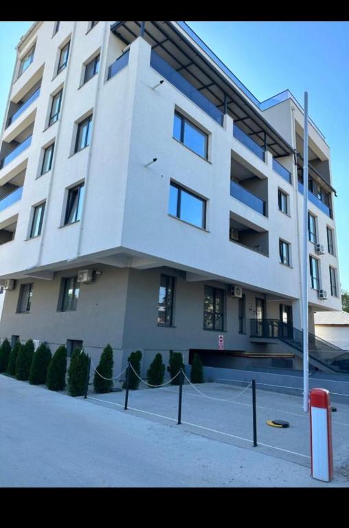 a large white building with a tennis court in front of it at Garsoniera Zona Centrala in Craiova