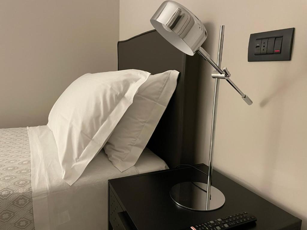 łóżko z biurkiem z lampką i poduszką w obiekcie La Galleria Lodge w mieście Parma