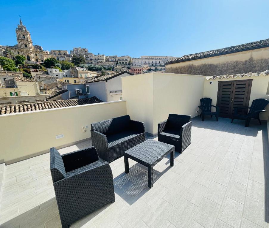a patio with chairs and a table on a roof at Casa Scribano in Modica