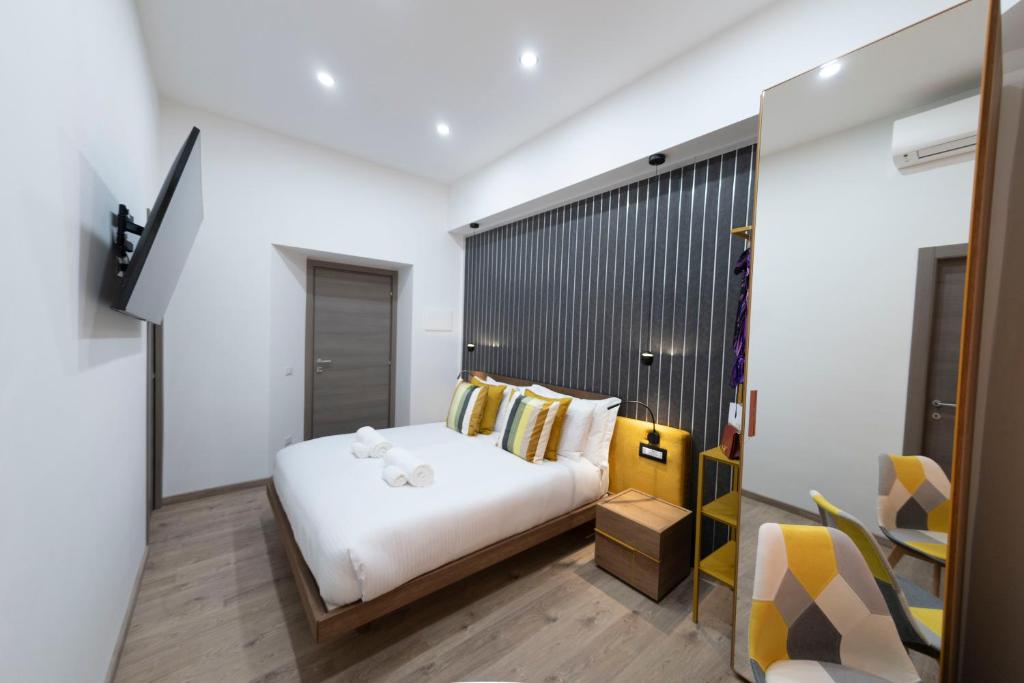 - une chambre avec un lit blanc dans l'établissement Cola Suites Apartments, à Rome