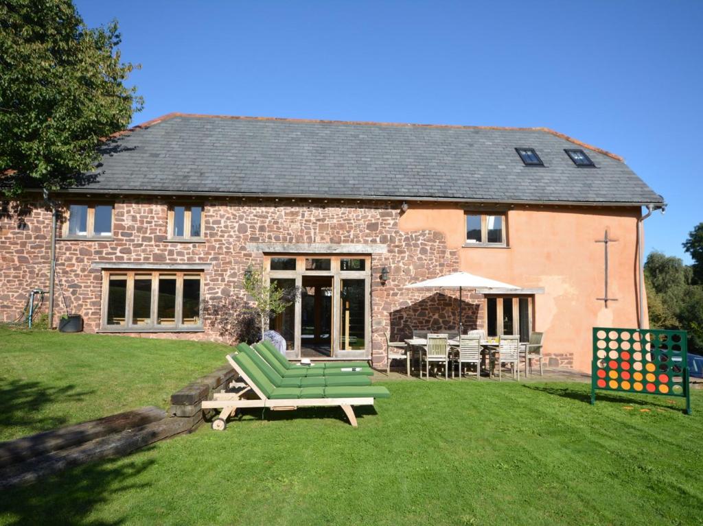 a brick house with a green couch and a table at 3 bed in Bickleigh HOBAR in Thorverton