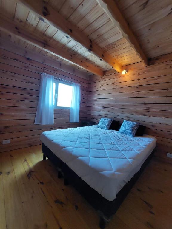 a bedroom with a bed in a log cabin at Pizarra Escondida in El Chalten