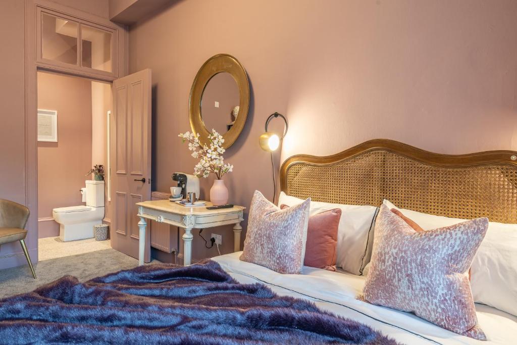 a bedroom with a large bed and a mirror at Boutique Home Stay Blossom in Paisley