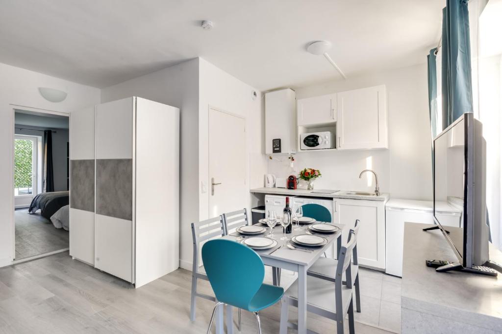 a kitchen and dining room with a table and chairs at 801 Suite Luxurys - Superbe Appartement in Bagnolet