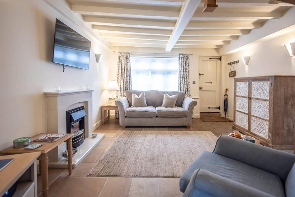 a living room with a couch and a tv at Pebbles Cottage, Southwold in Southwold