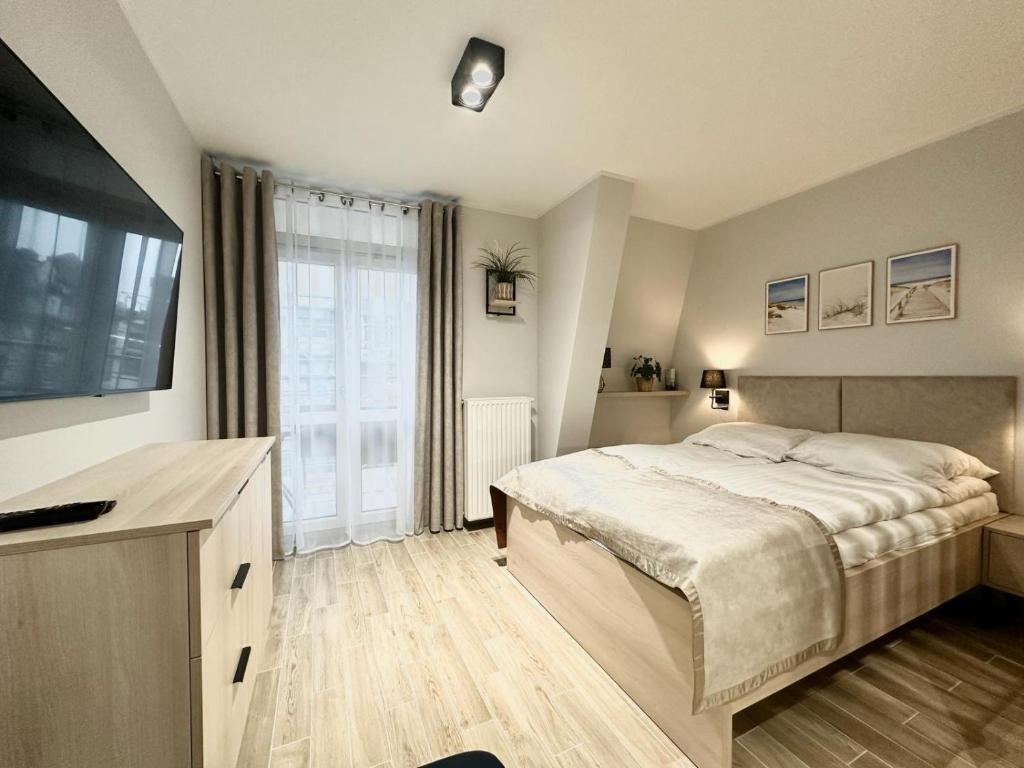 1 dormitorio con cama y ventana grande en Wyspa Uznam Promenada Willa Mistral en Świnoujście