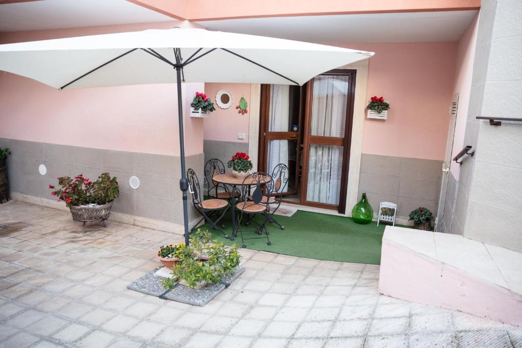 a patio with an umbrella and a table and chairs at B&B Flower House in Fasano