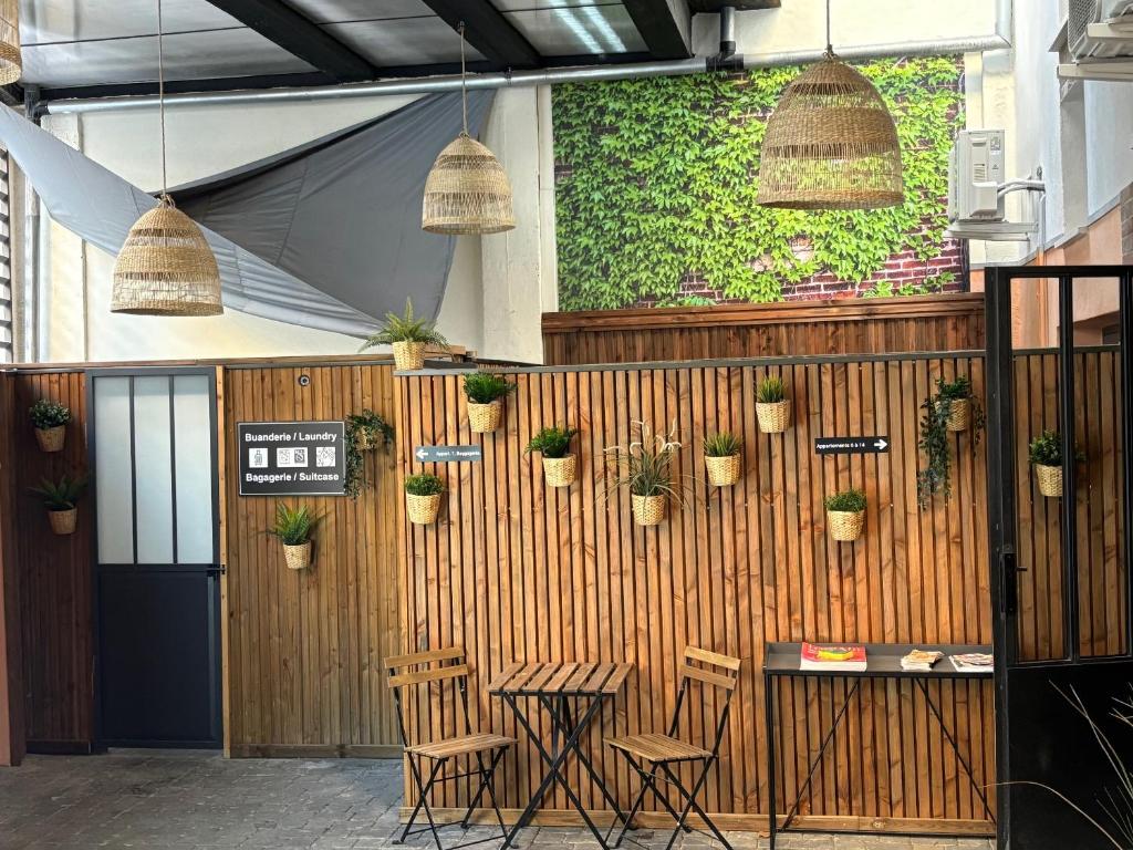 un restaurant avec un mur en bois orné de plantes en pot dans l'établissement Casa Hotel, à Aix-en-Provence