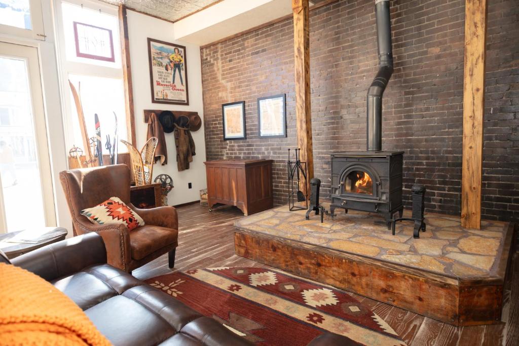 a living room with a brick wall with a fireplace at The Frenchman Suites in Silverton