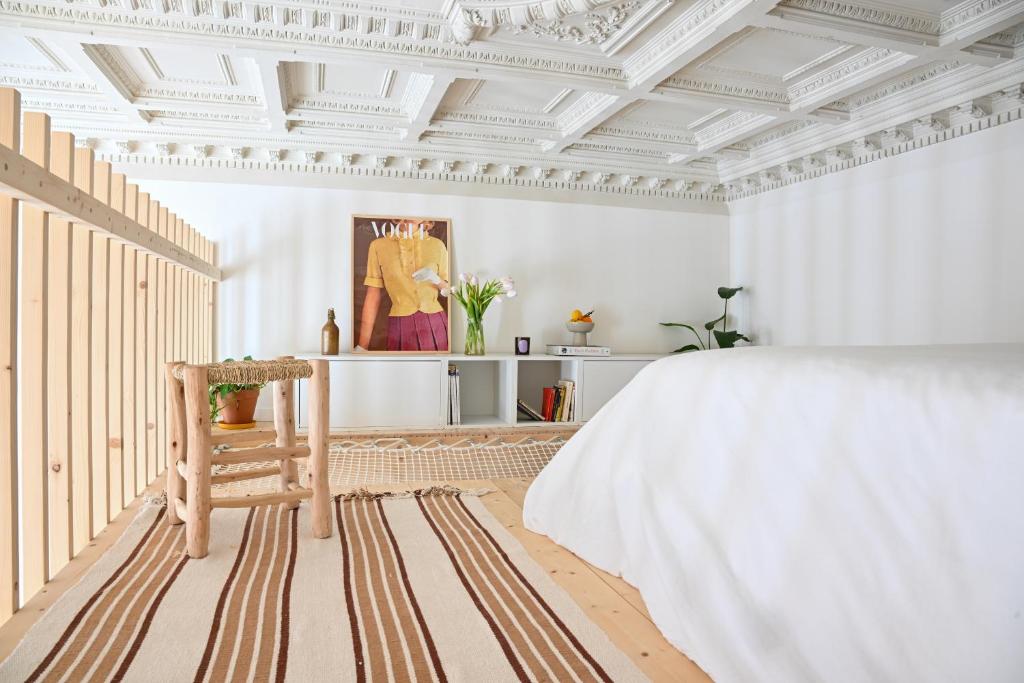 a bedroom with a white ceiling and a bed and a chair at Appartement gare Saint jean in Bordeaux