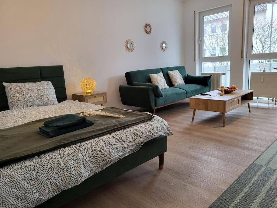 a bedroom with a bed and a couch and a table at Studio-Priv.Parkplatz-Balkon-Wlan-Netflix-SmartTV in Deizisau