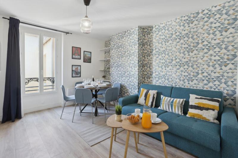 867-Suite Mimosa - Superb Apartment في مونتروي: غرفة معيشة مع أريكة زرقاء وطاولة