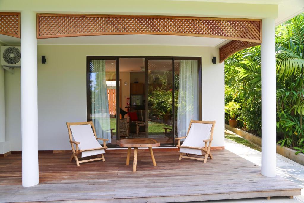 a front porch of a house with two chairs and a table at Villa Voilier in Mahe
