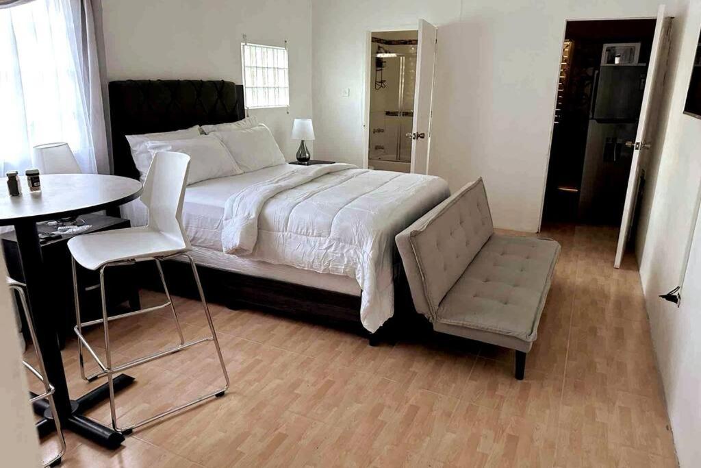 a bedroom with a bed and a table and a chair at Eagles Nest Villa Studio AC TV WIFI Fan Luxury Modern in Albion