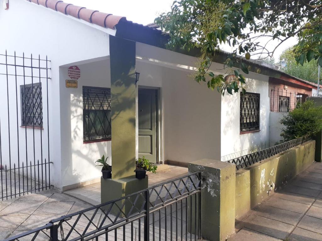 a white house with a door and a fence at Salta Paradise in San Bernardo