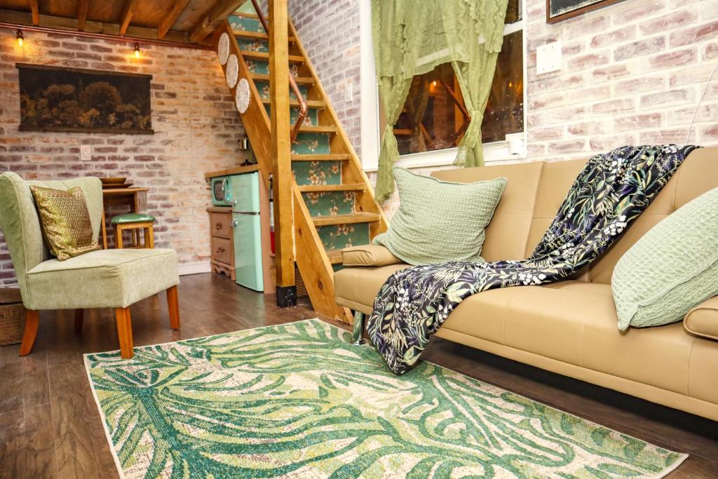 a living room with a couch and a staircase at Miami Tiny Vintage Cottage in Hialeah