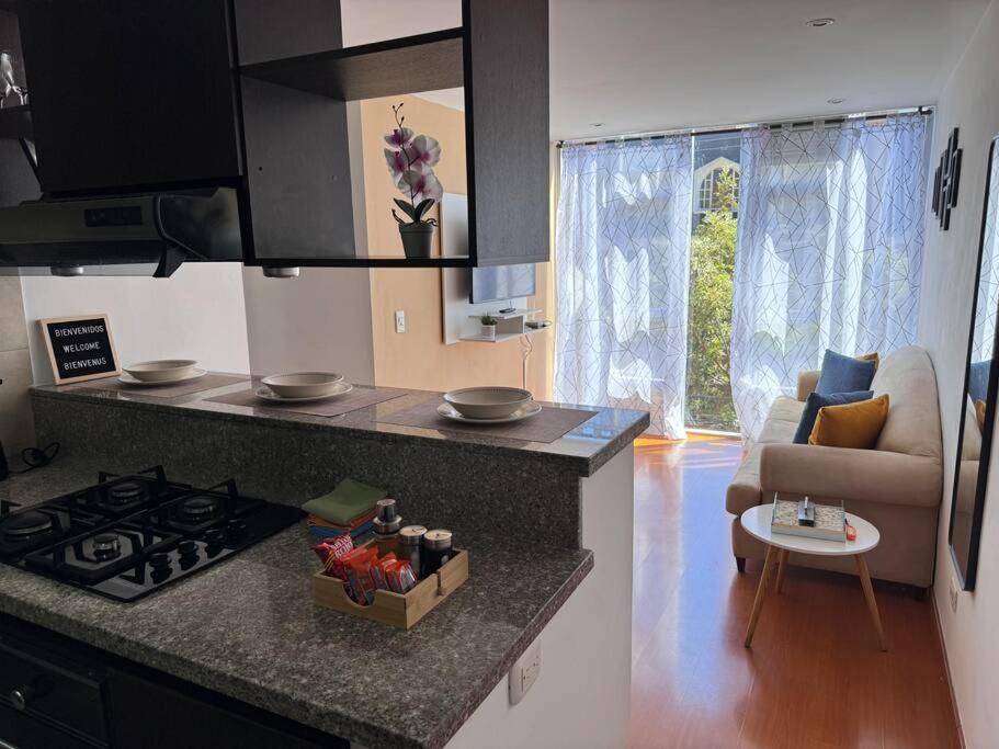 a kitchen with a counter top and a stove top oven at Acogedor apartamento cerca a Unicentro in Bogotá