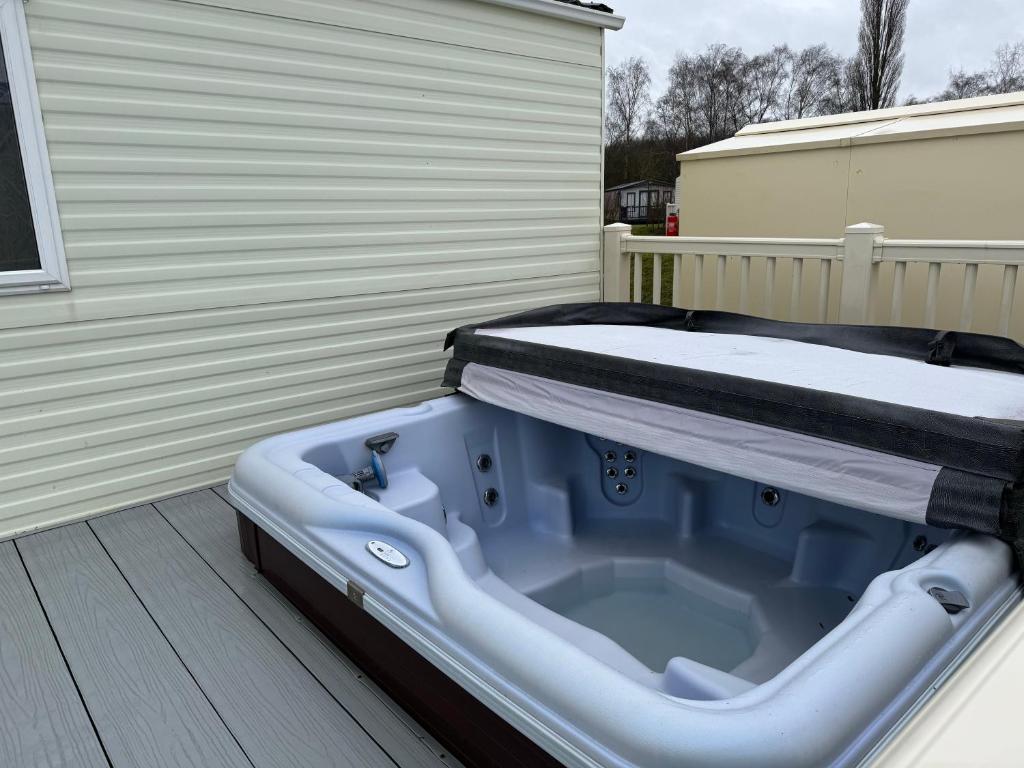 a blue tub sitting on a deck with a bed on it at Tattershall lakes in Tattershall
