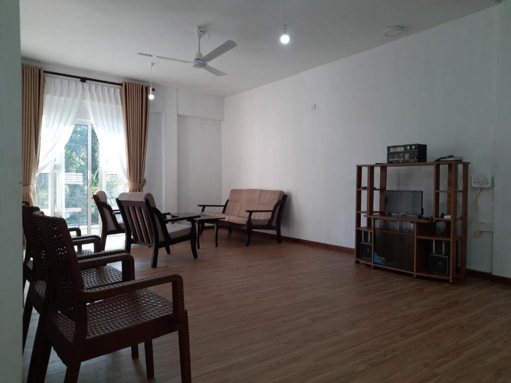 sala de estar con sillas, mesa y sofá en HEATHER NEST HOMESTAY - KUNDASALE en Kundasale
